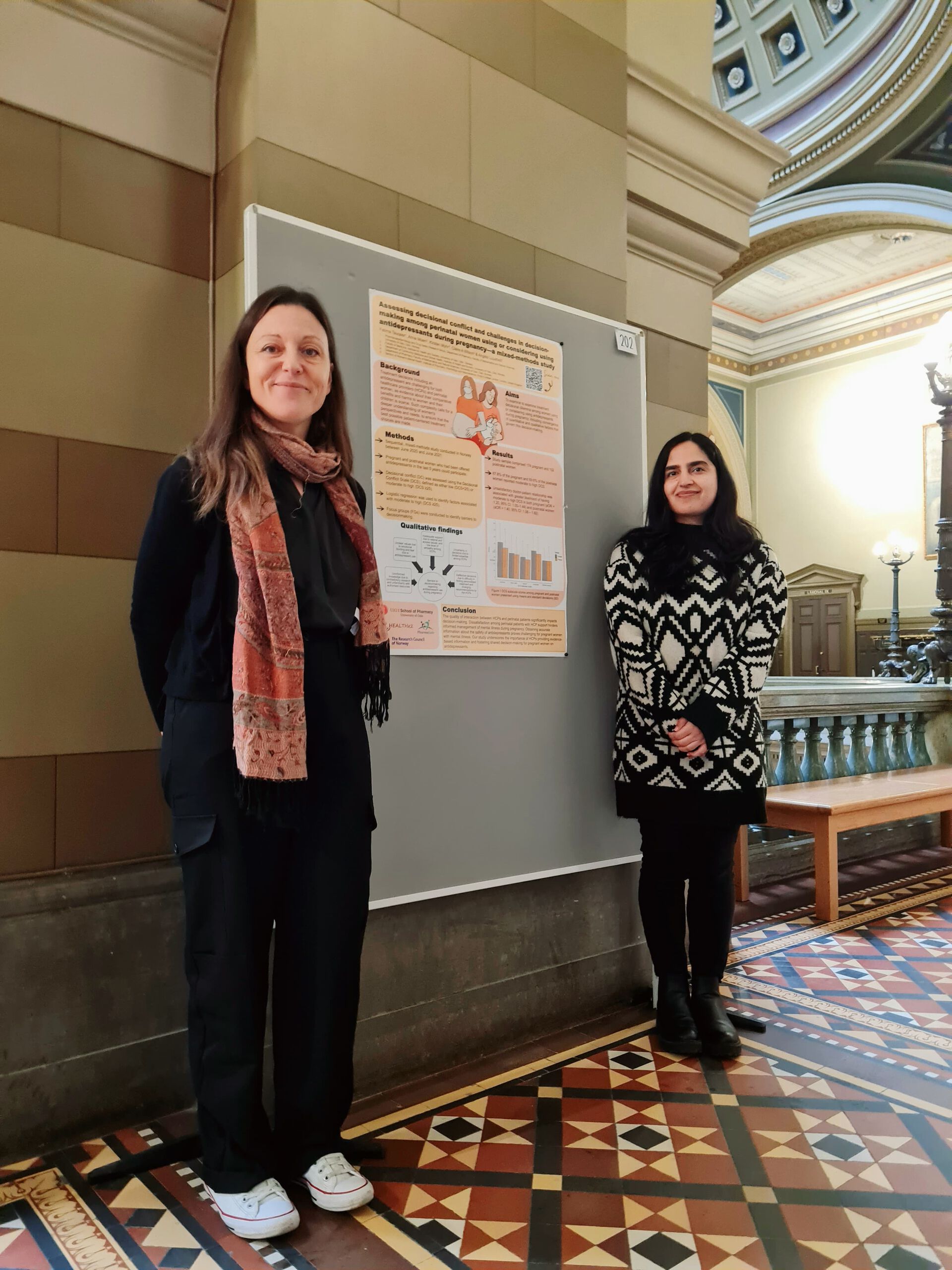 Two researchers in front of a poster