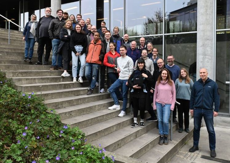 Image contain: a group of peopled standing as a group on a staircase. The group of people is everyone connected to the LENS group, ranging from engineers to professors to master students.  Team.
