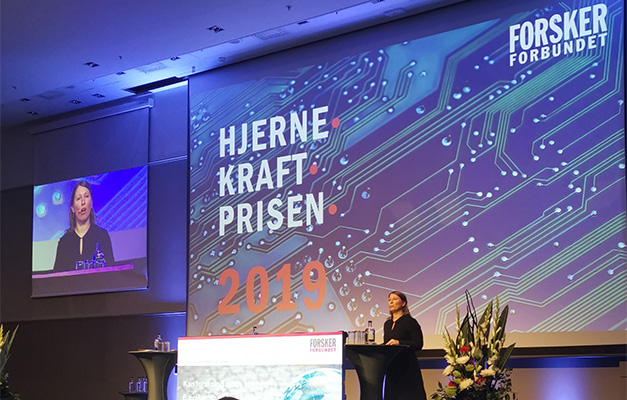 Leder for Forskerforbundet Guro Lind offentliggjør vinnerne av Hjernekraftprisen 2019 på det forskningspolitiske seminaret den 12.11.19 på Radisson Blu Scandinavia, Oslo. Foto: Forskerforbundet