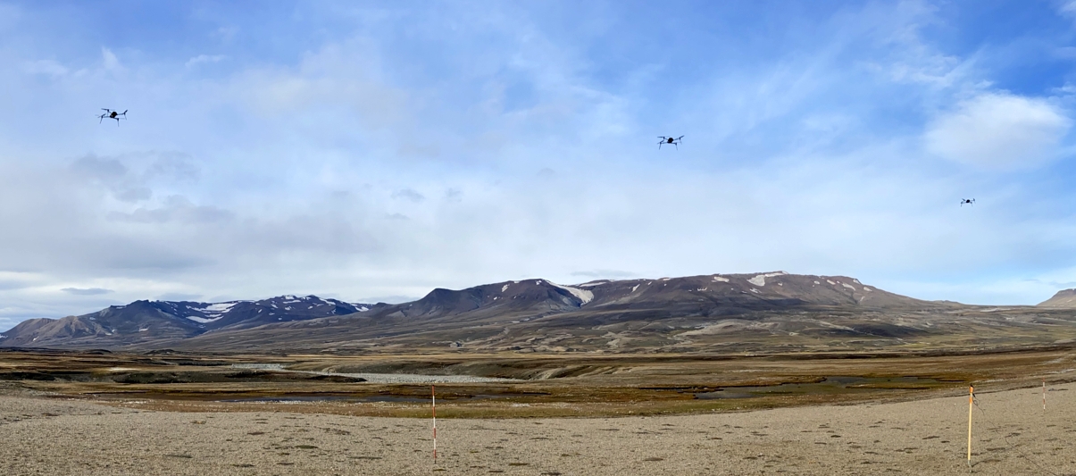 Foto: En testflyvning med en liten sverm på tre droner som alle bærer instrumenter for CO2-analyser. flyturen ble utført ute i felt i Nordøst-Grønland, august 2022 Foto: Prosjektteamet/ N. Pirk