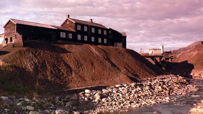 Foto: Smeltehytta på Røros med slagg av avfall frå smelteprosessen av stein ifrå gruvene på Røros Kobberverk. Ei stor elv renn like ved og vert forureina. Foto: Pixabay/torill_ivers0