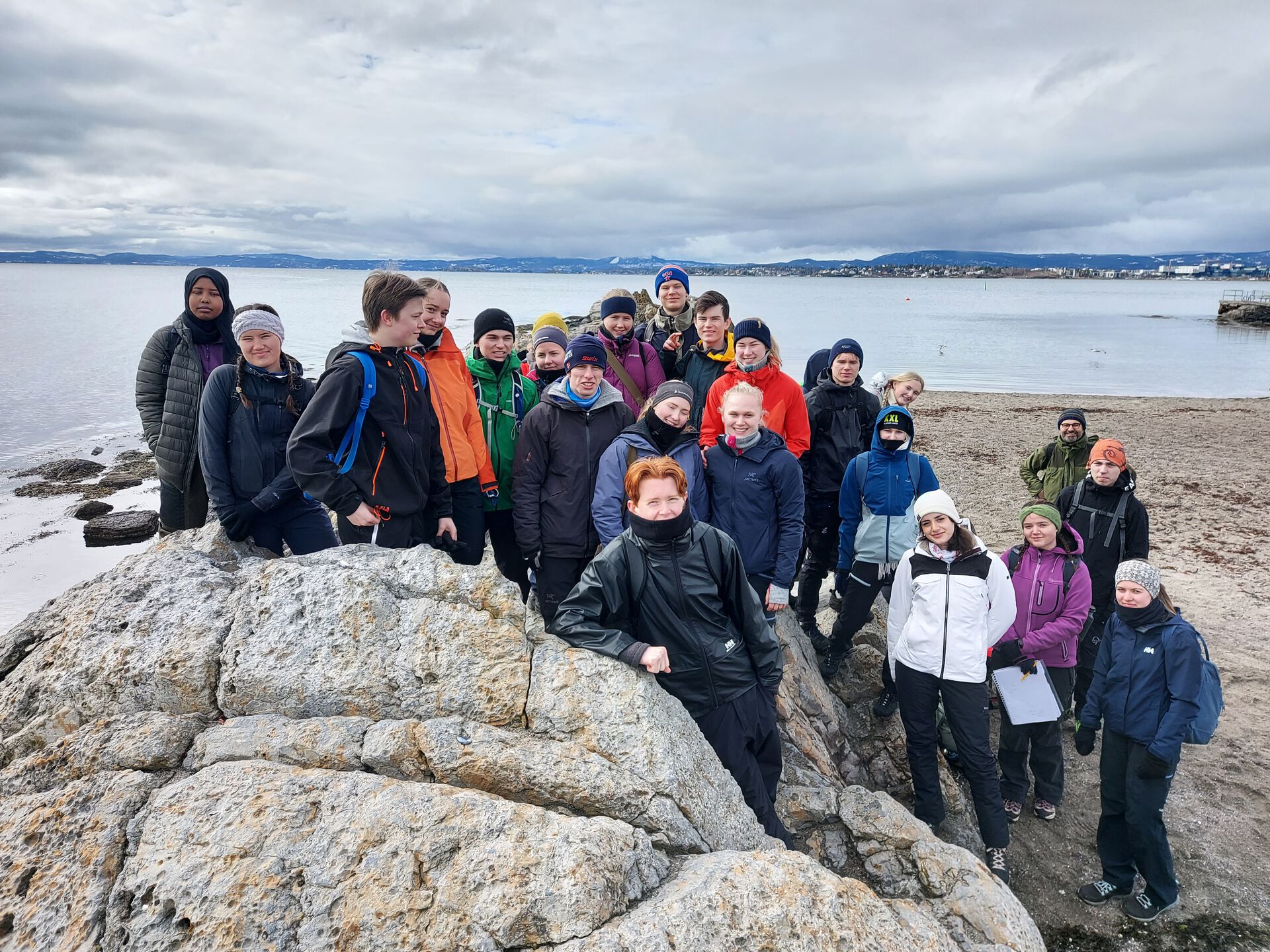 Elever som står bak en geologisk formasjon på Huk. 