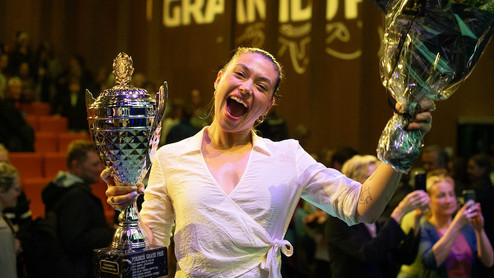 Happy woman with trophy and flowers