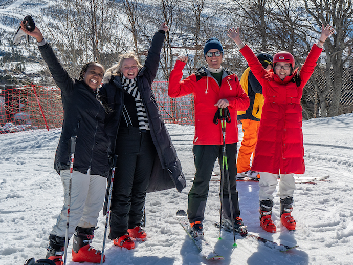 4 glade folk ute i snøen med ski