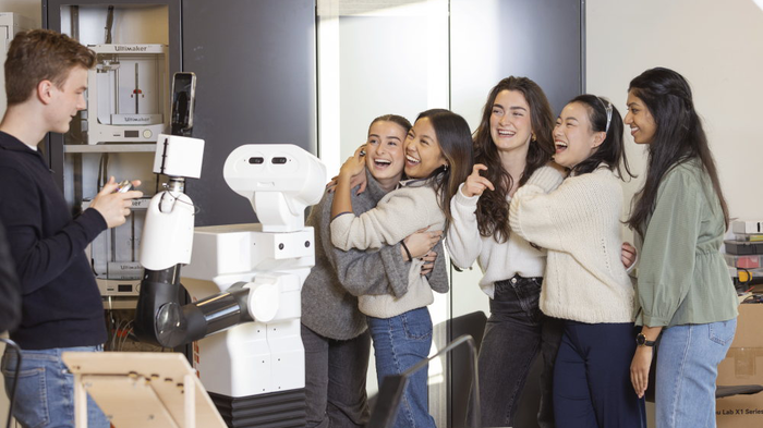 En robot tar selfie med en gruppe studenter